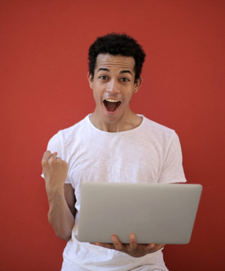 man looking at a laptop and excited